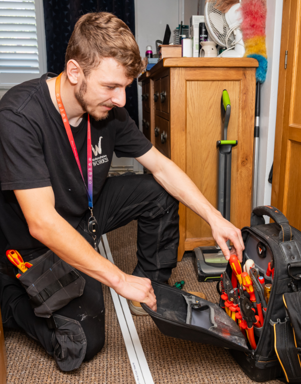 Repair technician with tool bag getting ready for a job in a customer's home