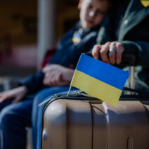 Ukrainian refugee family waiting for train in station, Ukrainian war concept.